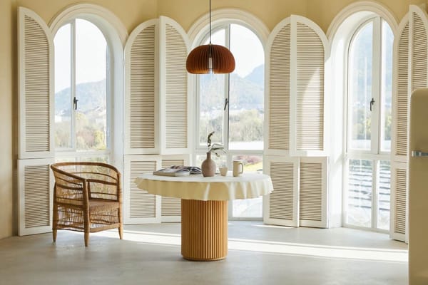 sala con decoración sustentable, ventanales grandes, mesa de madera